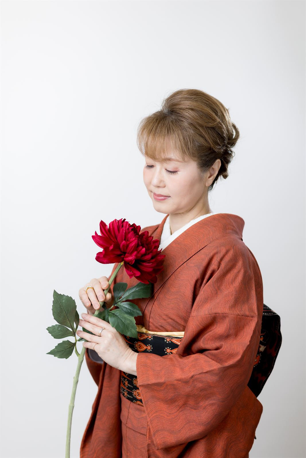 Woman in kimono holding a flower